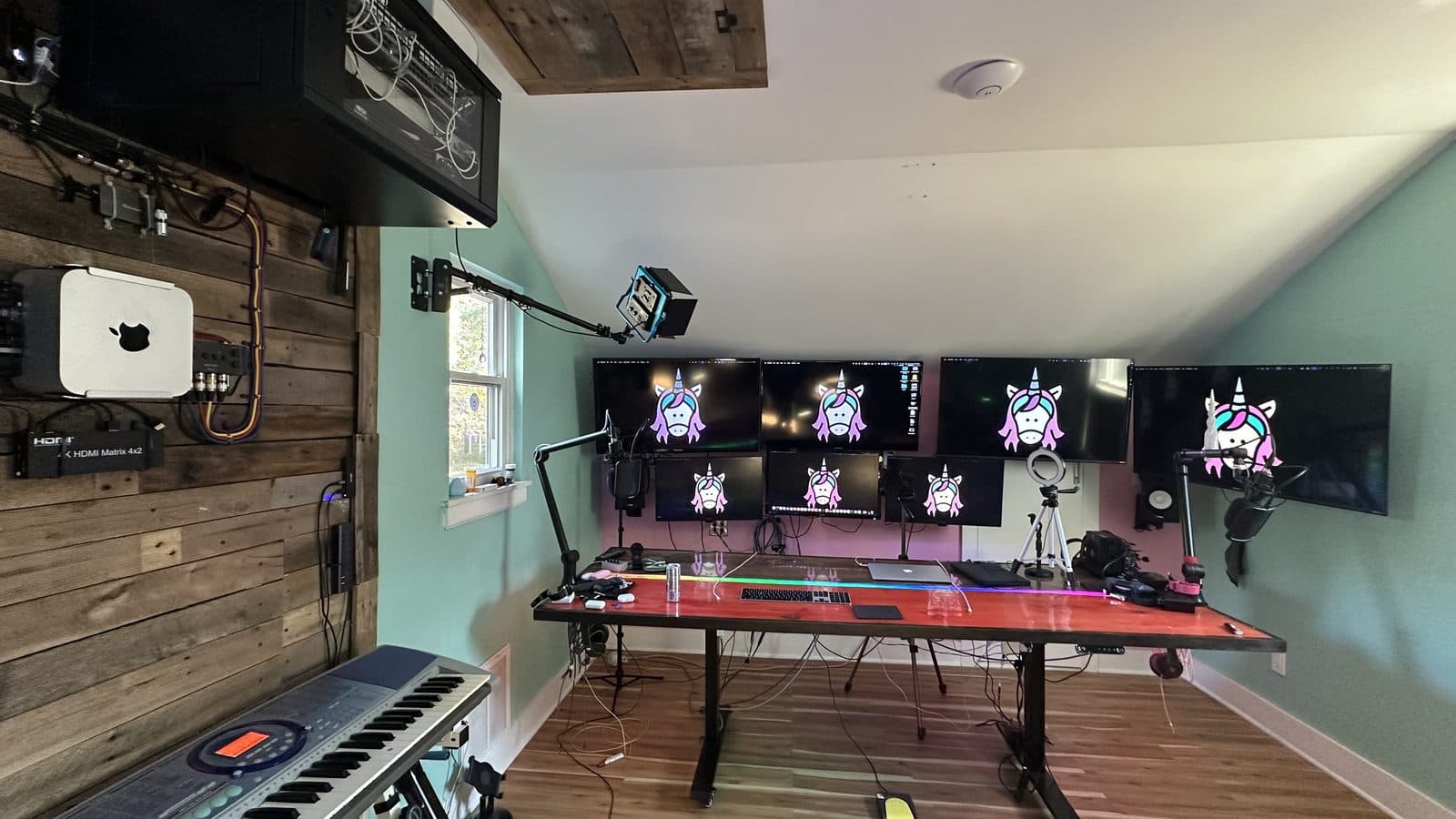 The Magic Unicorn studio: monitors, microphones, and a keyboard in a wood-paneled room